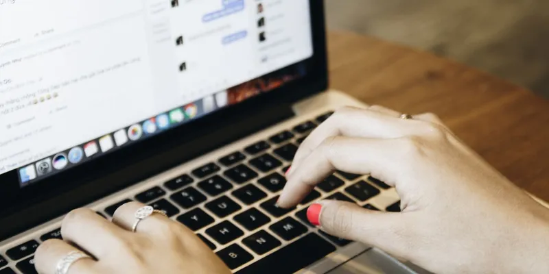 Manos escribiendo en una laptop con una aplicación de mensajería abierta