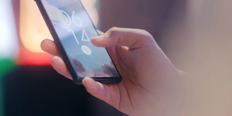 Mano sosteniendo un celular con lector de huella