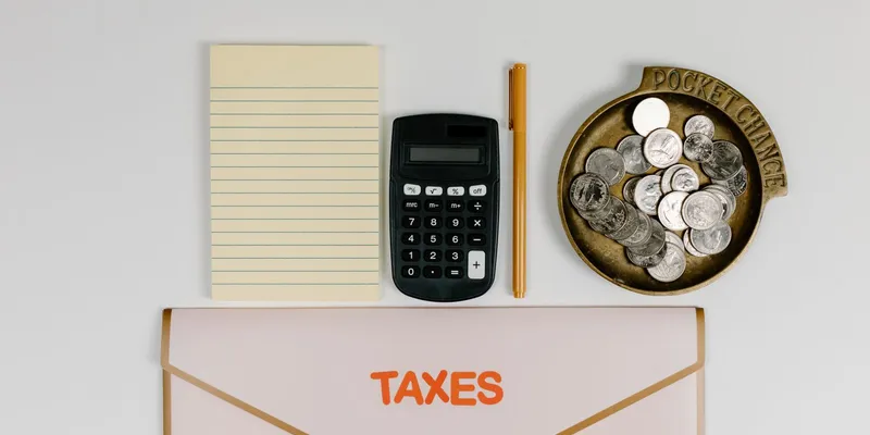 Calculadora, monedas y documentos sobre un escritorio