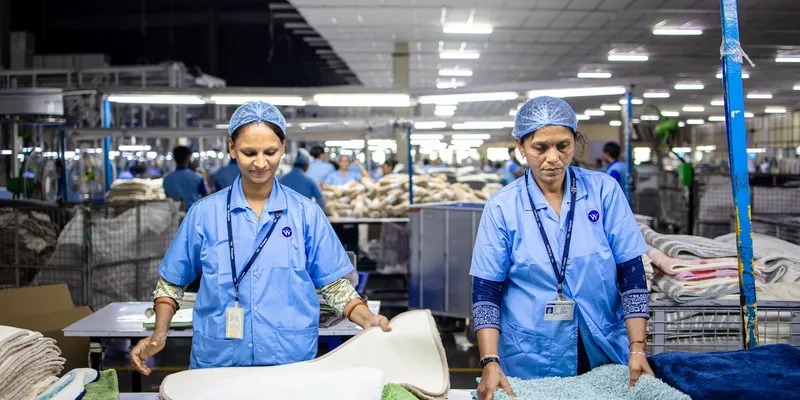 Dos trabajadoras clasificando producto en una planta textil iluminada