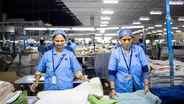 Dos trabajadoras clasificando producto en una planta textil iluminada