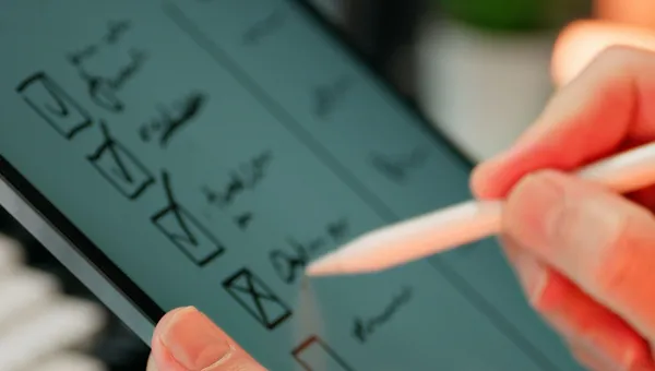 Manos llenando una lista de verificación digital en una tableta con un lápiz óptico