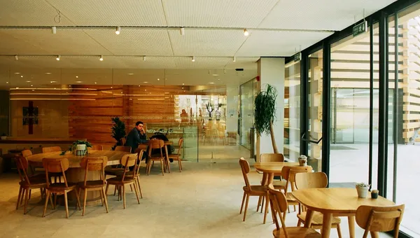 Comedor amplio con mesas de madera y ventanales